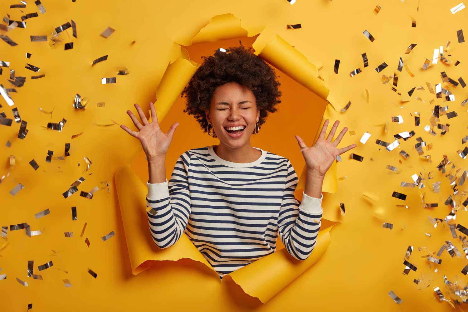 competition winner lady busting through a sheet of paper with gold tickets